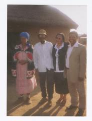 Four people posing before a house in South Africa