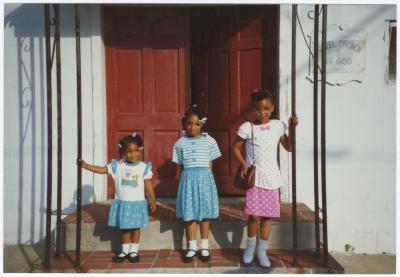 Three girls outside the Gospel Church of God