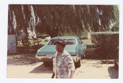 Woman walking by a blue car