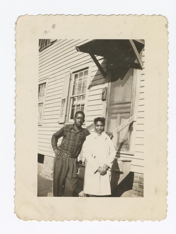 Two people standing before a door