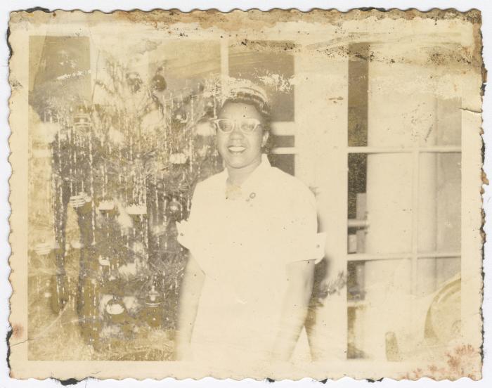 A woman in front of a Christmas tree