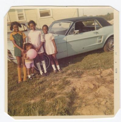 Four girls posing with automobile