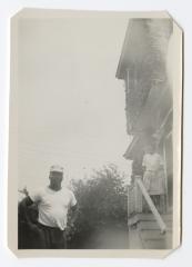 Man standing with a woman on a staircase in the background