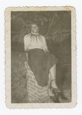 Betty Wilson sitting on brick pillar