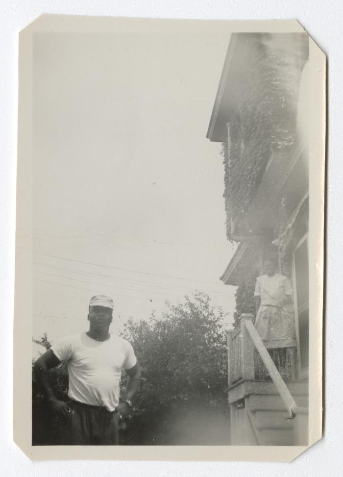 Man standing with a woman on a staircase in the background