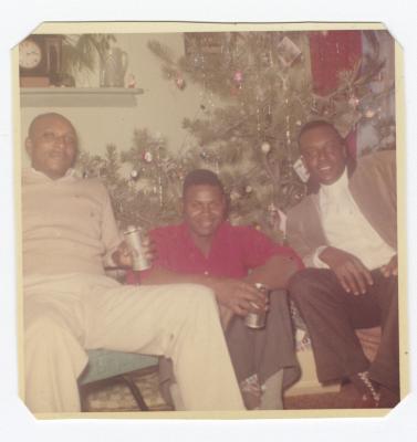 Three men in front of the Christmas tree