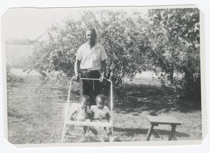 Man pushing two toddlers in a stroller