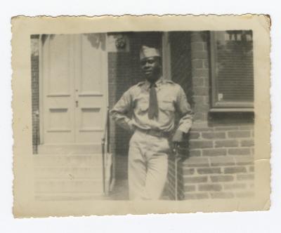 Soldier leaning against a brick building