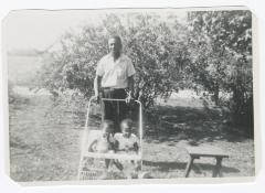 Man pushing two toddlers in a stroller