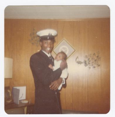 Man in naval uniform holding a baby