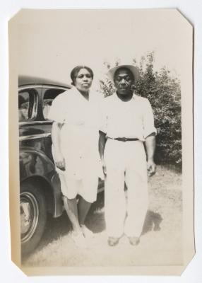 Man and woman standing next to an automobile