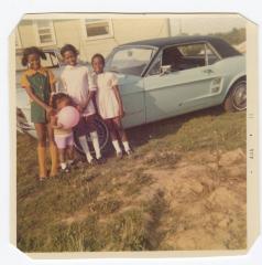 Four girls posing with automobile