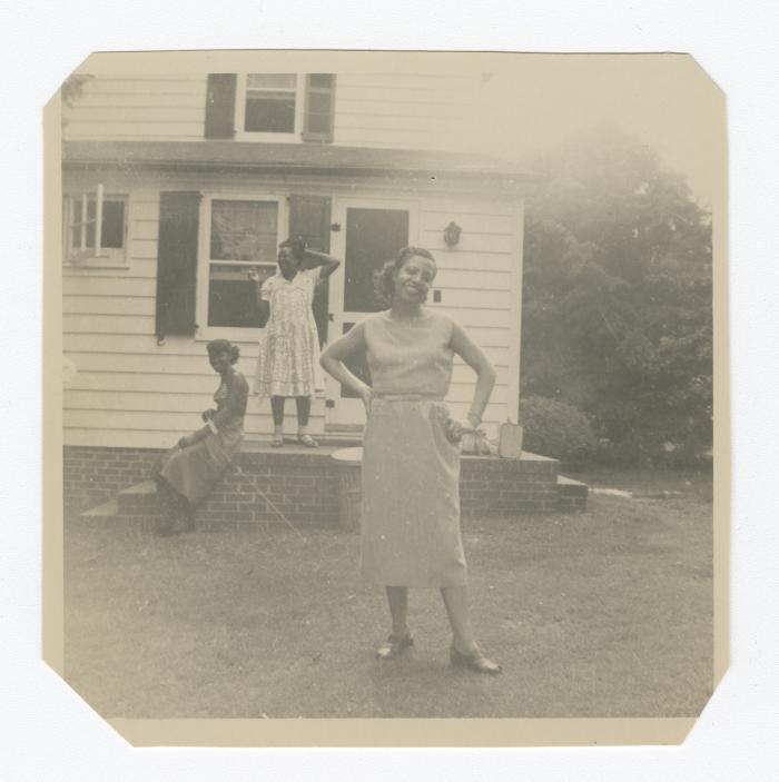 Three women in front of a house