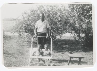 Man pushing two toddlers in a stroller
