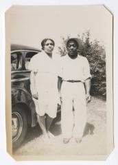 Man and woman standing next to an automobile
