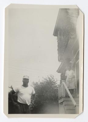 Man standing with a woman on a staircase in the background