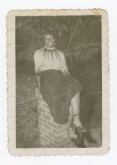 Betty Wilson sitting on brick pillar