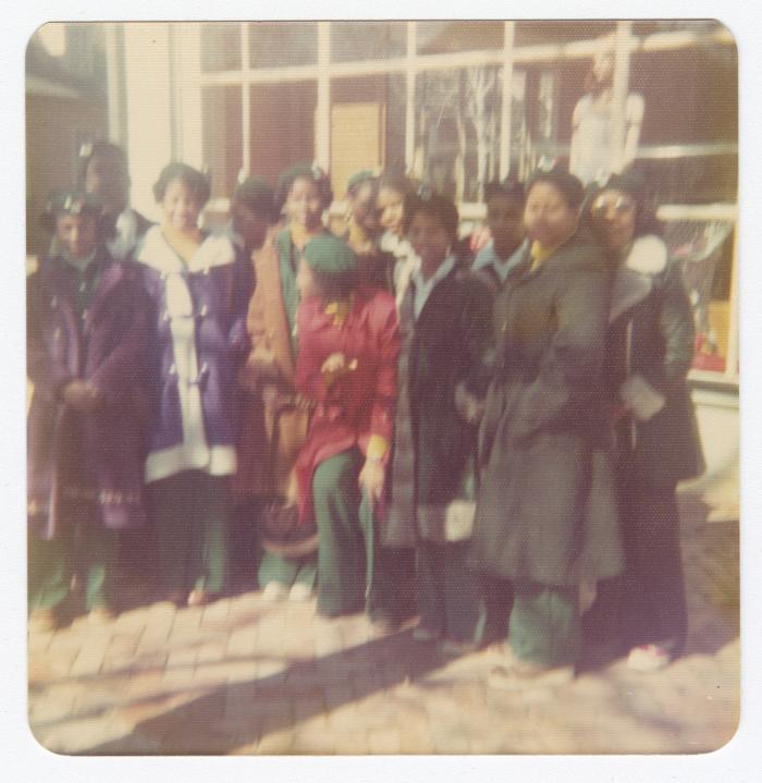 Girl Scouts standing in front of a store window