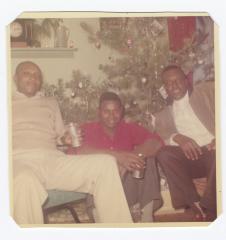 Three men in front of the Christmas tree
