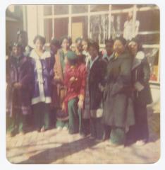 Girl Scouts standing in front of a store window