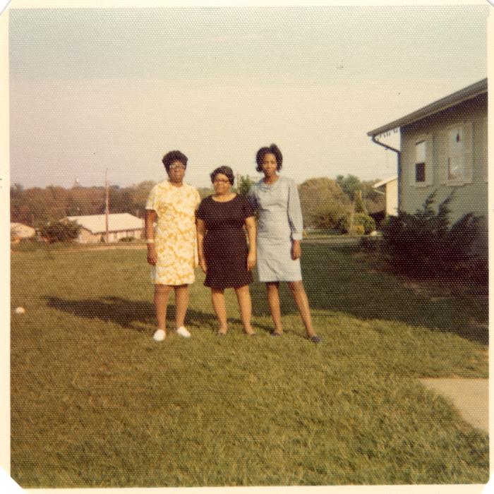 Three women in a yard