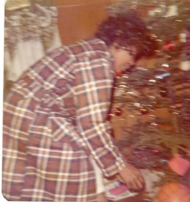 Woman crouching down by the Christmas tree