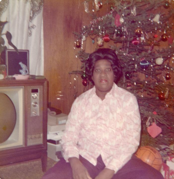 Woman sitting in front of a television and Christmas tree