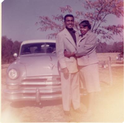 Couple standing in front of car