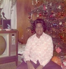 Woman sitting in front of a television and Christmas tree