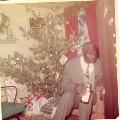 Man sitting in front of a Christmas tree