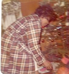 Woman crouching down by the Christmas tree