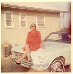 Woman sitting on the hood of a car