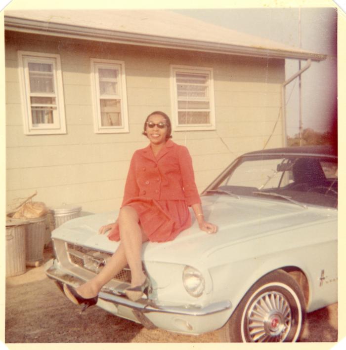 Woman sitting on the hood of a car