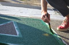 Painting a green letter "A" for the Black Lives Matter street mural