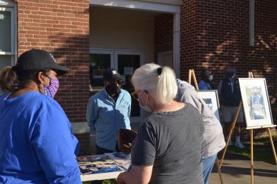 Community members gathering around table of photos