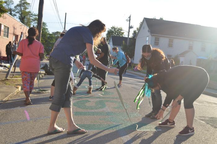 Women removing tape from the Black Lives Matter street mural