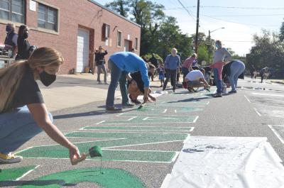 Large group of people painting Black Lives Matter mural