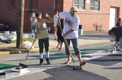 Woman and young boy painting the Black Lives Matter street mural