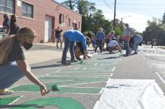 Large group of people painting Black Lives Matter mural