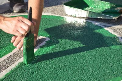 Painting a green letter of the Black Lives Matter street mural