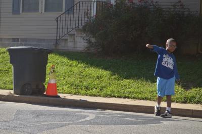 Young boy emulating the Black Lives Matter street mural fist