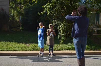 Woman taking a photo of two children with the Black Lives Matter street mural