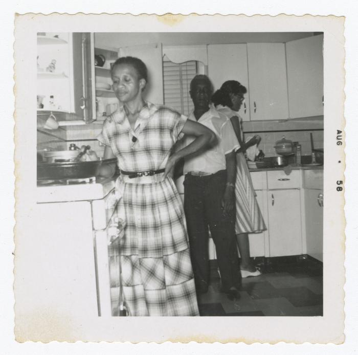 Three people cooking in a kitchen