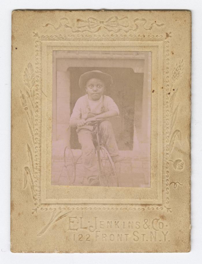 Framed picture of a young boy on a tricycle