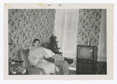 A man and a woman sitting on a couch in a living room