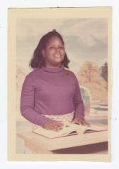 A young girl smiling with an open book