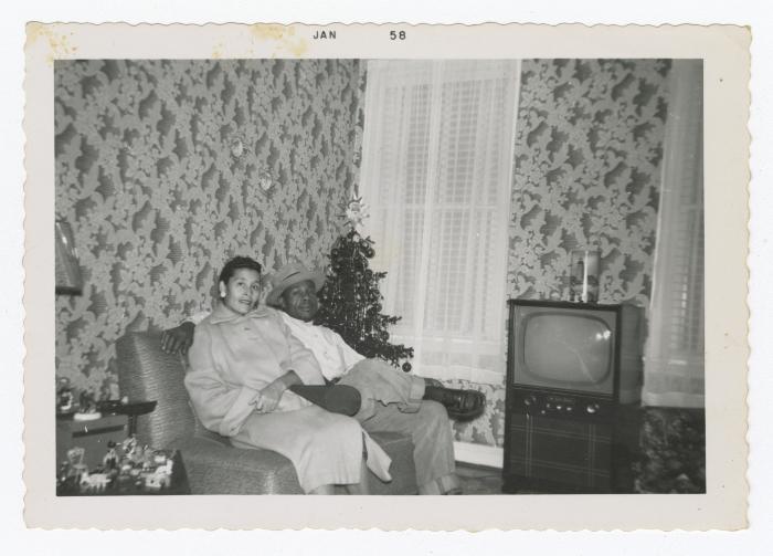 A man and a woman sitting on a couch in a living room