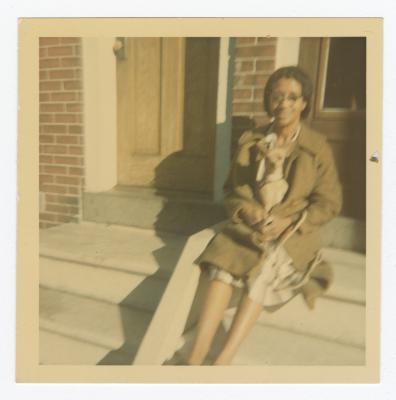 Woman sitting outside with a small dog on her lap