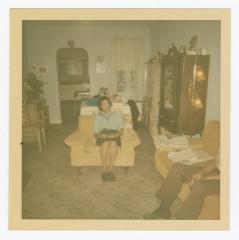 A woman, man, and dog in a living room