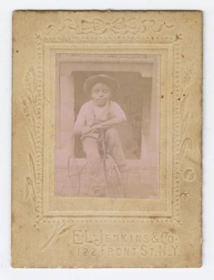 Framed picture of a young boy on a tricycle